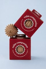 Red 'Calm Companion' packaging with a textured object on a light blue background