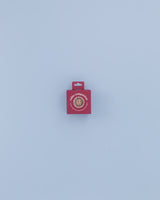 Small red box with a circular cutout revealing a textured stress relief ball inside, labeled 'Calm Companion™' for anxiety and stress relief, on a light blue background.